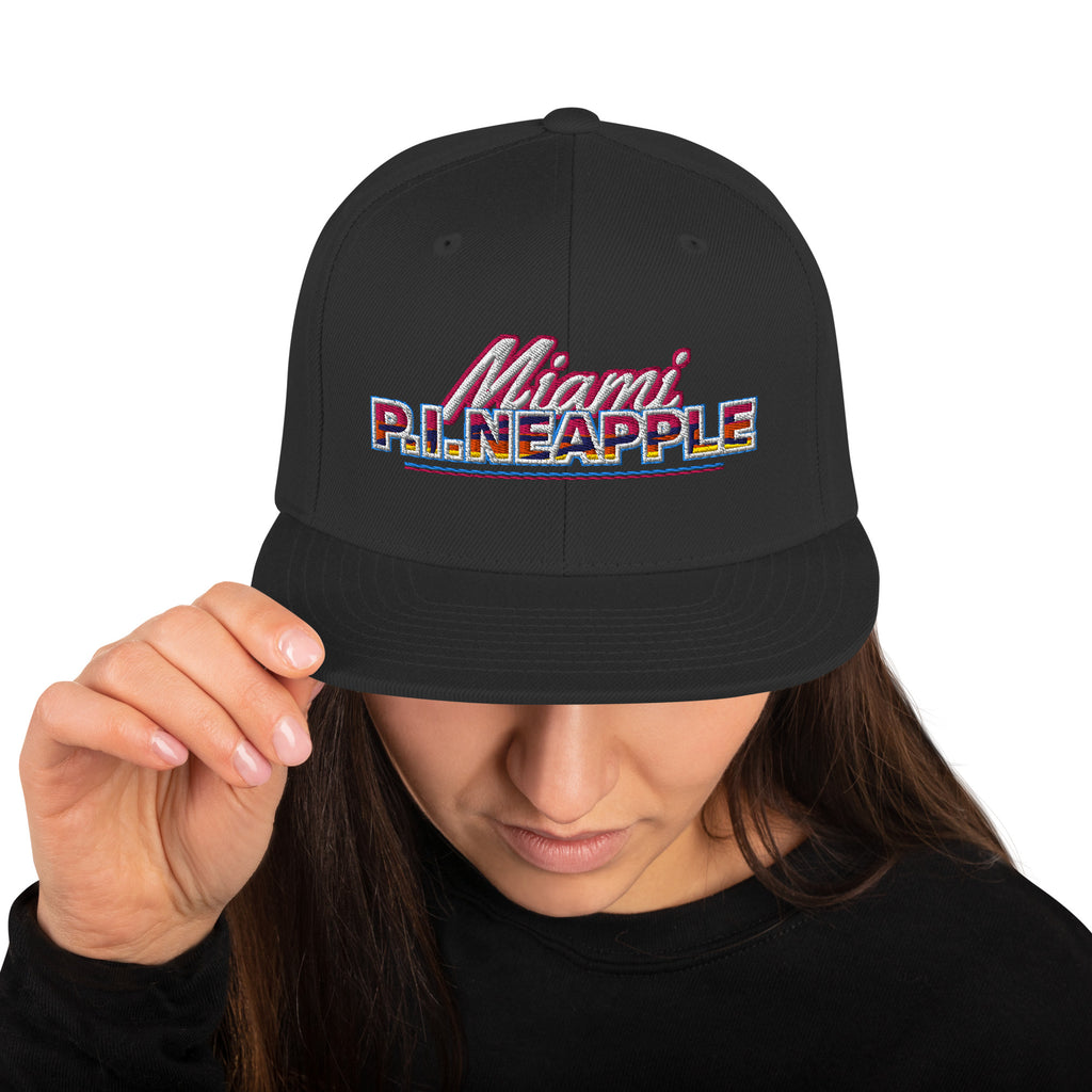 Black flat-brim snapback hat with embroidered Miami P.I.NEAPPLE pineapple logo