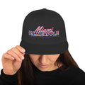 Black flat-brim snapback hat with embroidered Miami P.I.NEAPPLE pineapple logo
